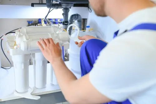 Technician installing a water filtration system in Broward, FL to improve water purification and overall water quality for homes and businesses